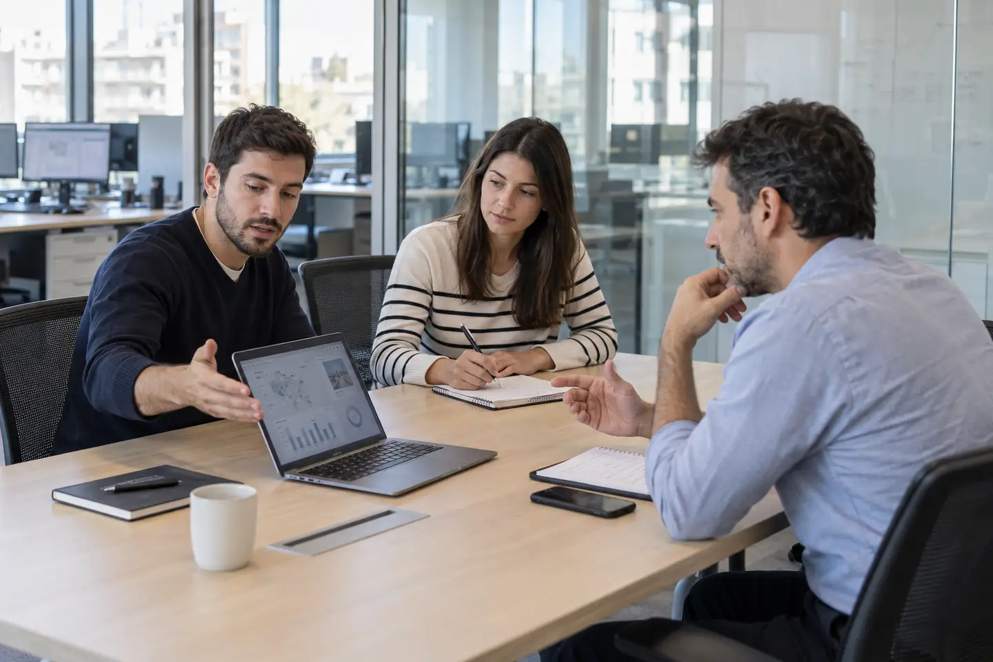 Una reunión de trabajo donde se repasa un tablero de indicadores en pantalla